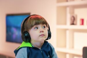 Young child with calm, content facial expression who is wearing headphones on