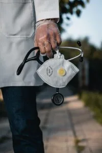 Healthcare professional holding a stethoscope and face mask