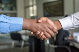 Two people shaking hands in a workplace